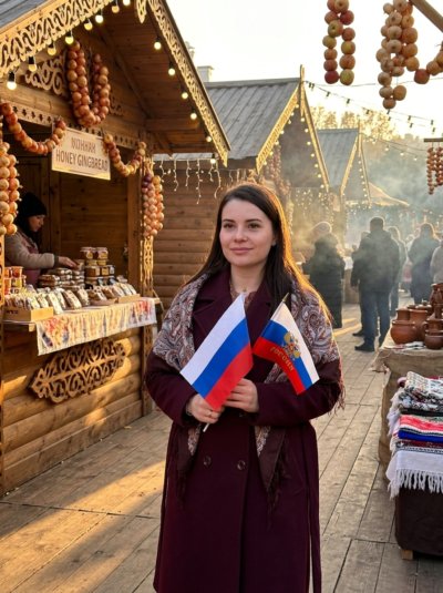 Девушка с флагом на осенней ярмарке: образ в бордовом пальто